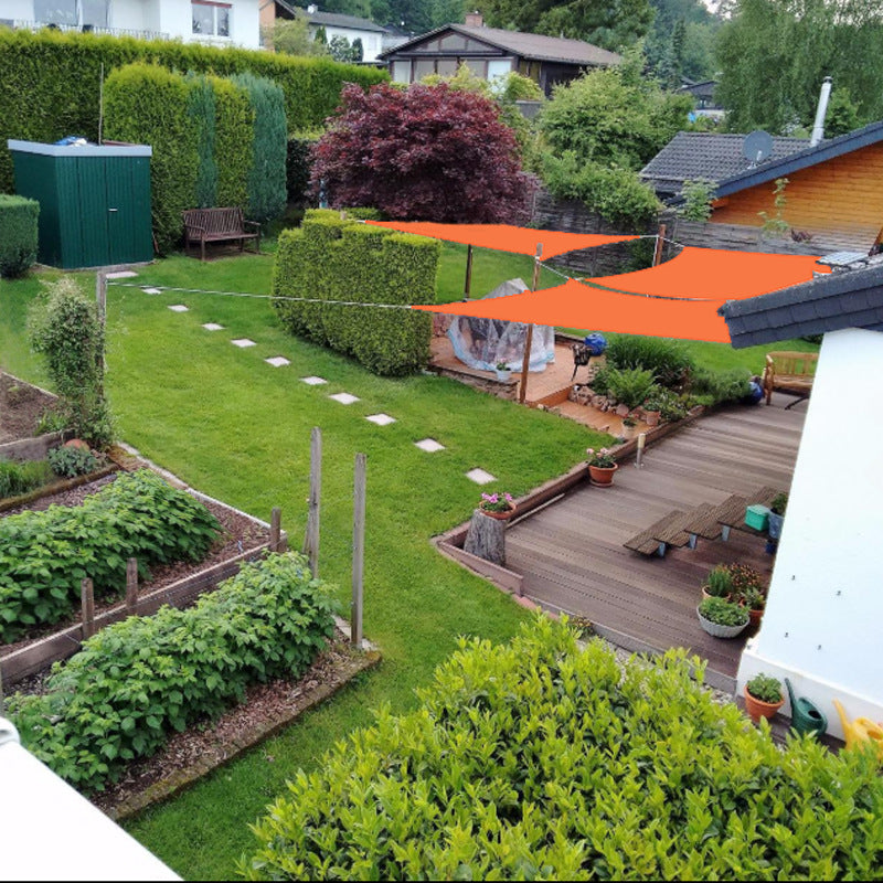 Backyard green grass, trees, bushes, vegetables, and sunshade in orange